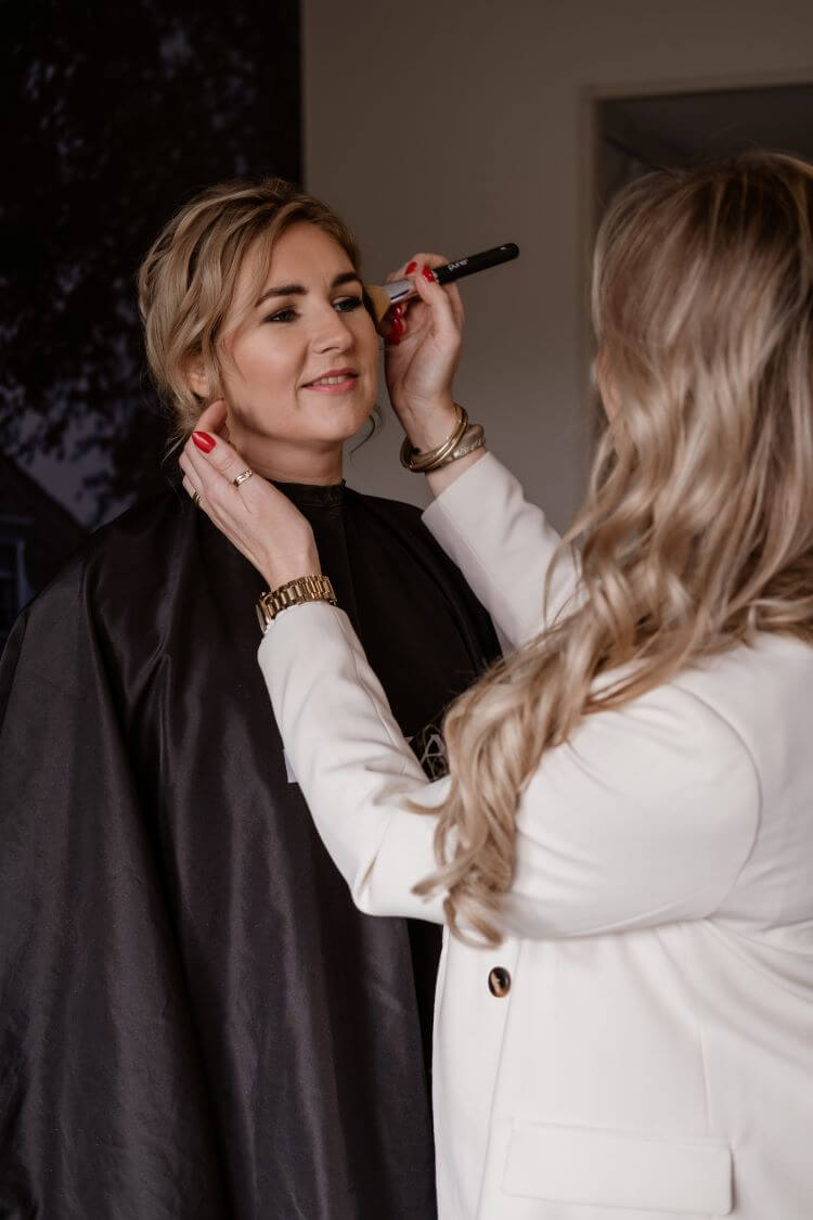 Een bruid wordt opgemaakt door bydebhairbeauty